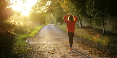 an image of a woman walking outside at dusk/mental wellness