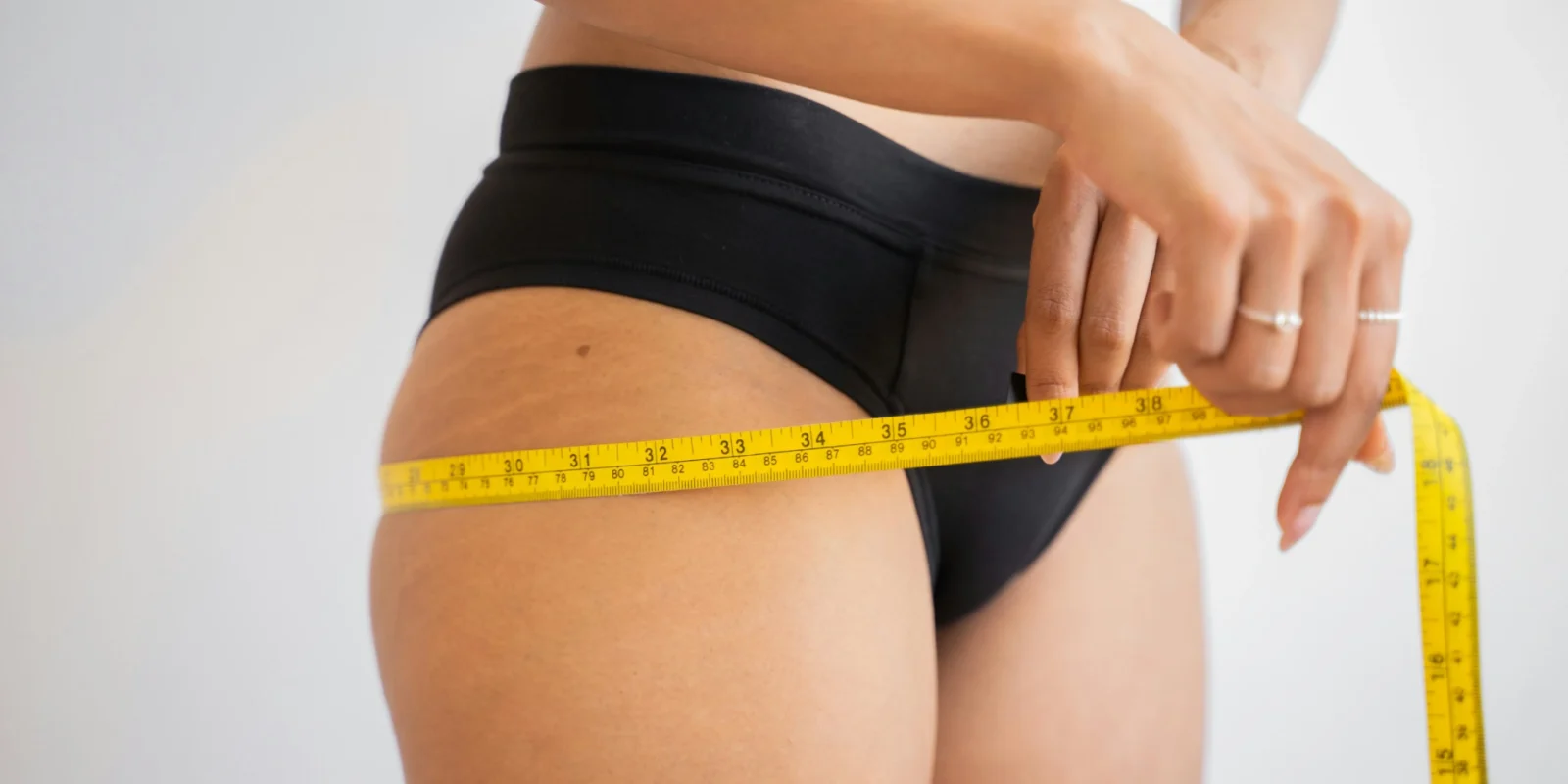 a woman measuring her body with measuring tape