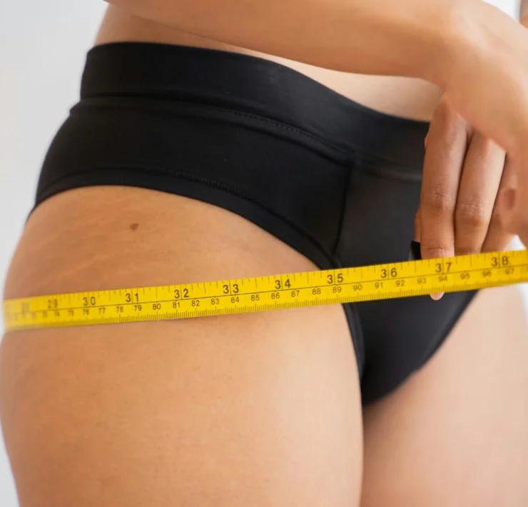 a woman measuring her body with measuring tape