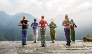 women do yoga overlooking mountains