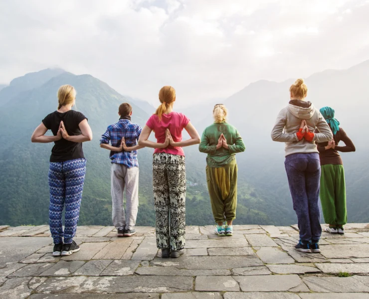 women do yoga overlooking mountains