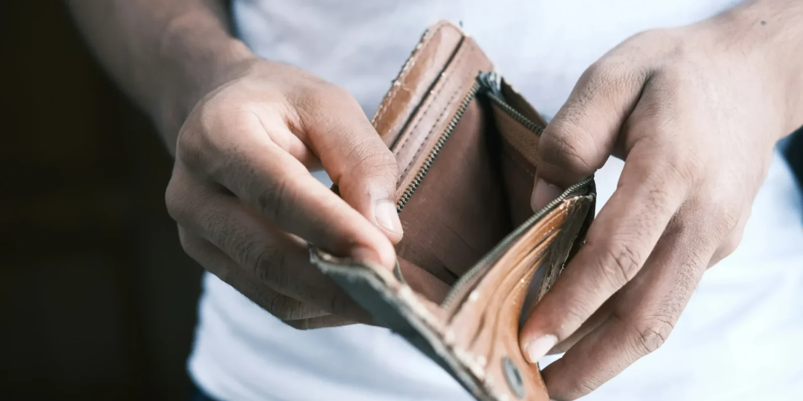 a man looking inside of an empty wallet