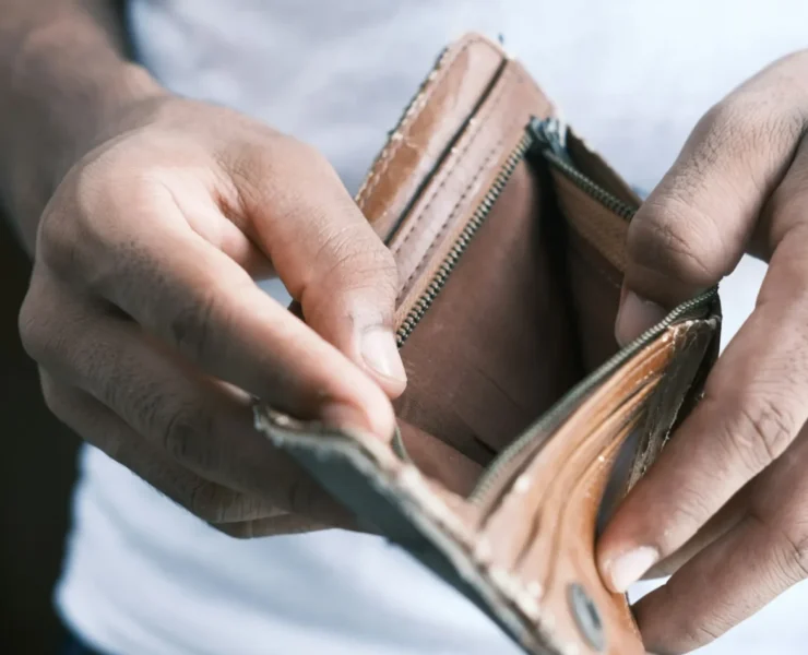 a man looking inside of an empty wallet