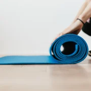 woman rolls up a yoga mat