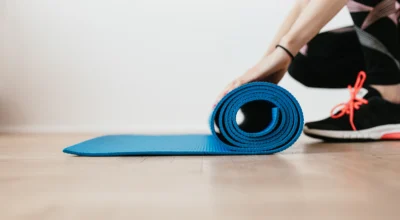 woman rolls up a yoga mat