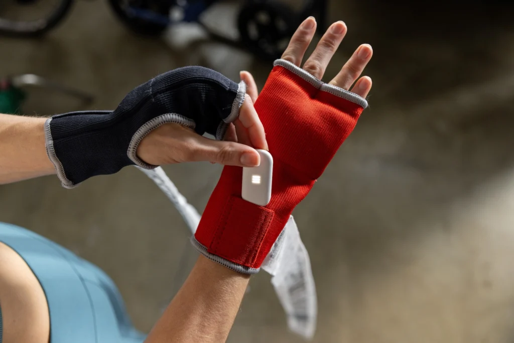 woman wears a boxing glove with a punch tracker