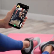 Woman working out with trainer on smartphone