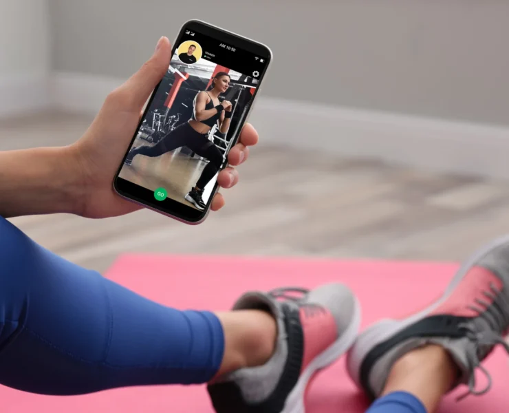 Woman working out with trainer on smartphone