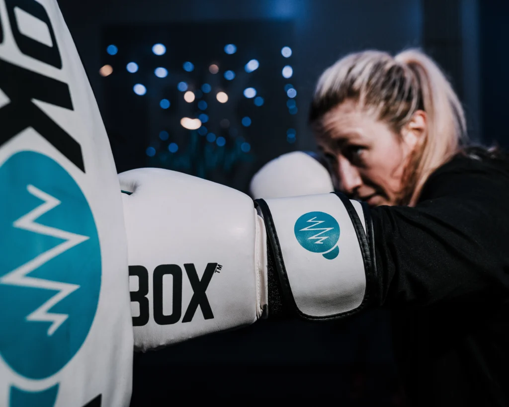 a woman hitting a bag at RockBox Fitness