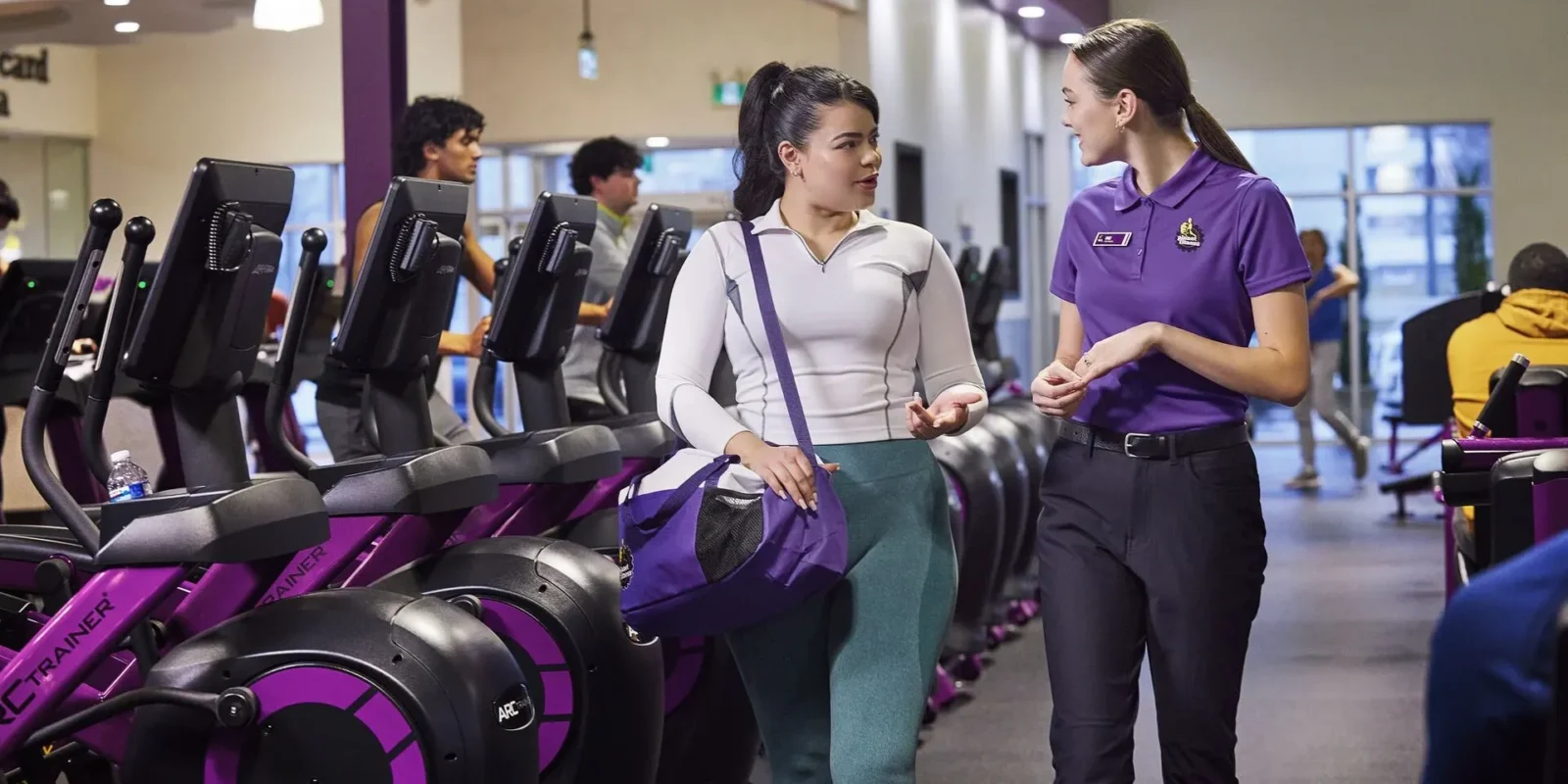 a new Planet Fitness member learning about the gym from a PF employee