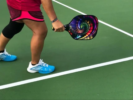 a person on a pickleball court holding a paddle