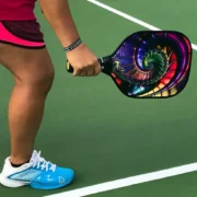 a person on a pickleball court holding a paddle