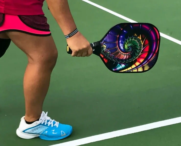 a person on a pickleball court holding a paddle