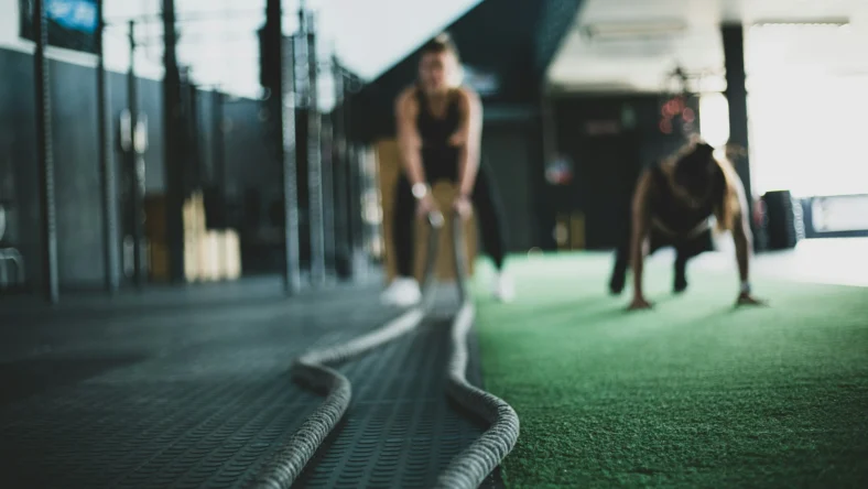 a woman working out with ropes in a gym