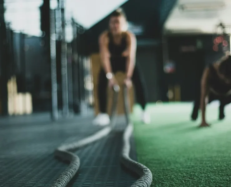 a woman working out with ropes in a gym