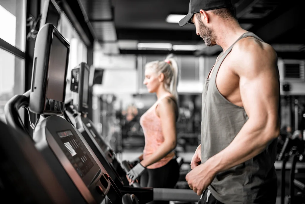 a man looking at woman while on treadmill