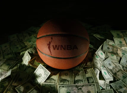 a WNBA branded basketball on top of various bills