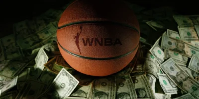 a WNBA branded basketball on top of various bills