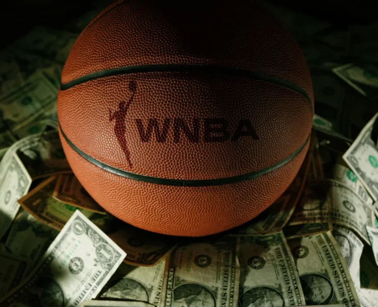 a WNBA branded basketball on top of various bills