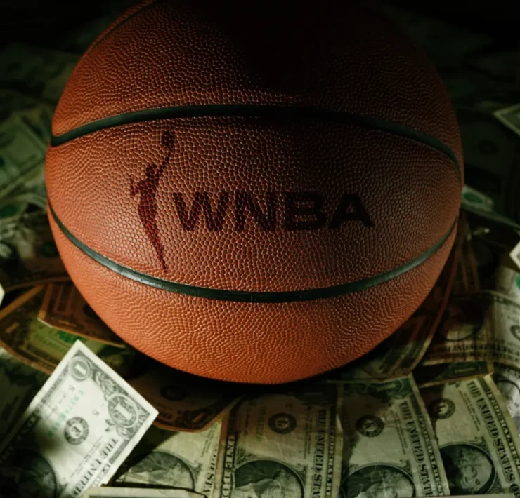 a WNBA branded basketball on top of various bills