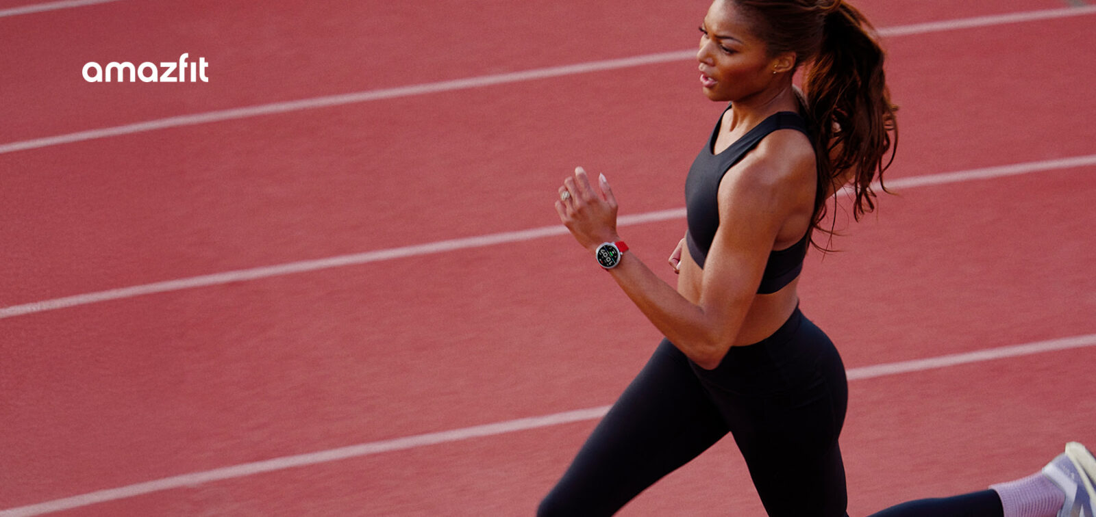 Gabby Thomas running on a track with Amazfit wearable on her wrist.