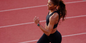 Gabby Thomas running on a track with Amazfit wearable on her wrist.