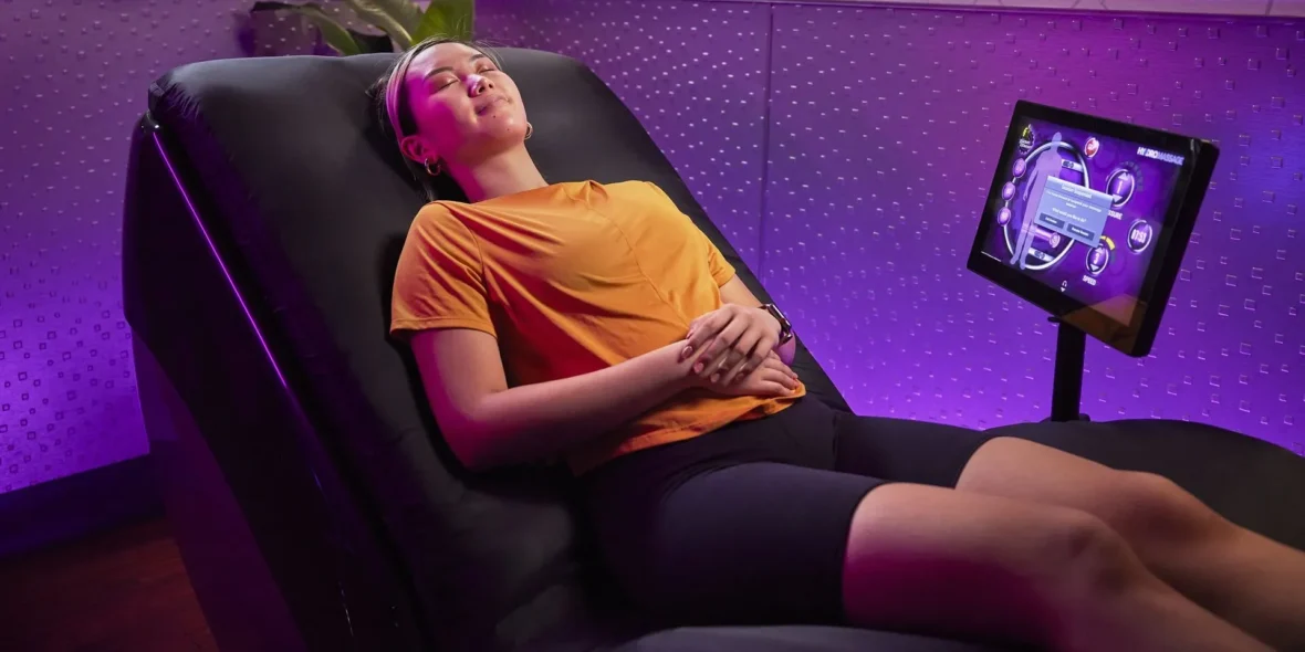 A woman is relaxing using the Planet Fitness HydroMassage lounger.