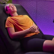 A woman is relaxing using the Planet Fitness HydroMassage lounger.