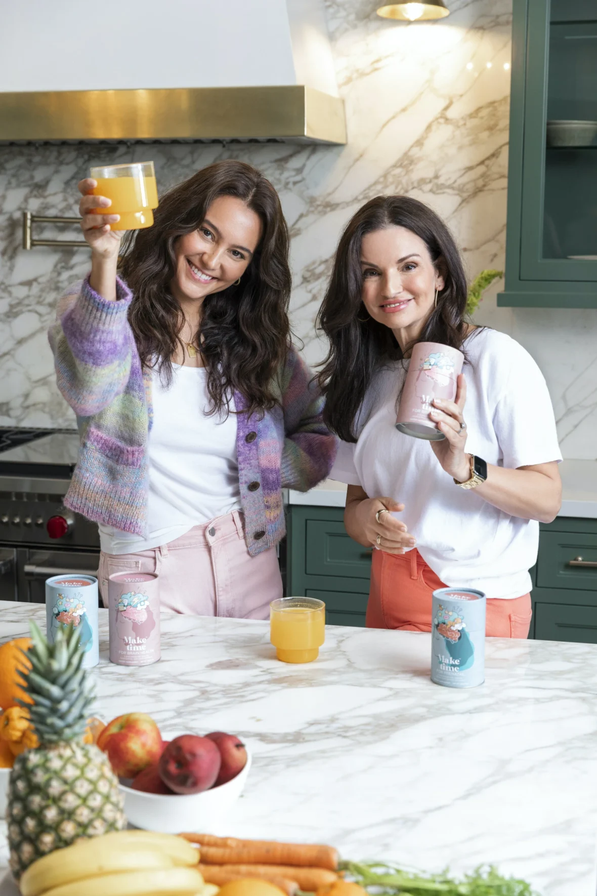 Make Time Wellness founders in a kitchen holding their products.