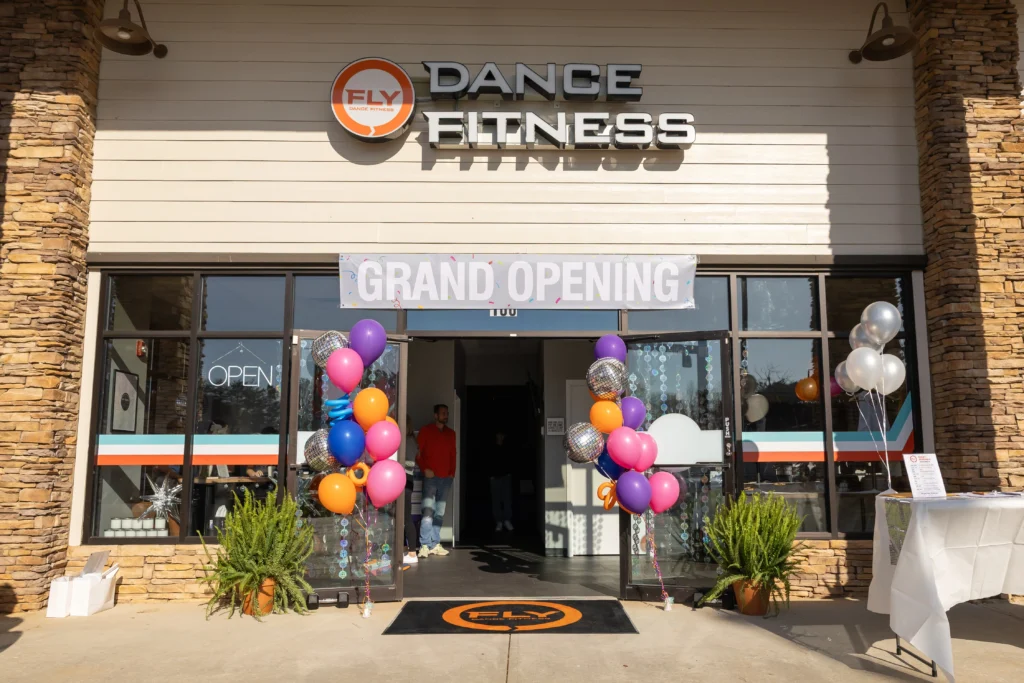 exterior shot of Fly Dance Fitness in Georgia with a grand opening sign.