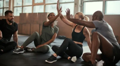 women and men high-five after a group fitness class