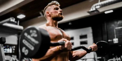 A man in a gym lifting weights.