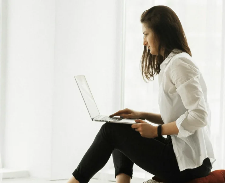 A woman sitting while on her computer.
