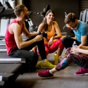 women and man talk near treadmills after a workout