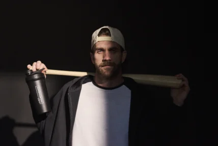 Bryce Harper holding a bat in the shadows.