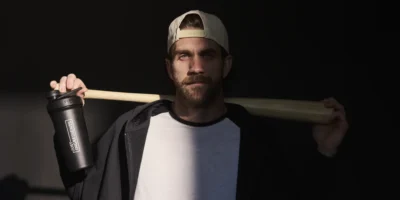 Bryce Harper holding a bat in the shadows.