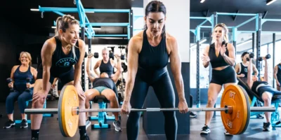 A BFT class in action with a woman lifting weights.