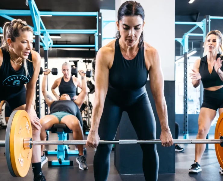 A BFT class in action with a woman lifting weights.