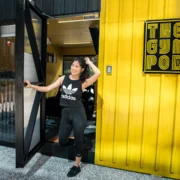 A girl outside of a Gym Pod shopping container in Hong Kong.