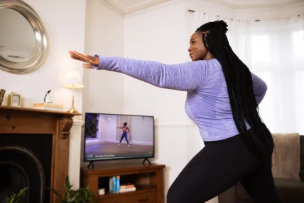 A woman working out in her living room with the guidance of Mvmnt.