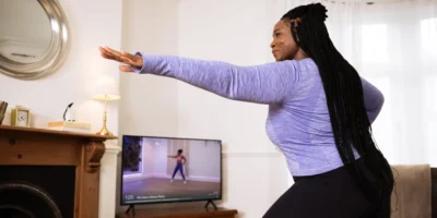 A woman working out in her living room with the guidance of Mvmnt.