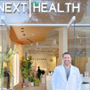 Dr. Darshan Shah poses in front of the Next Health entrance