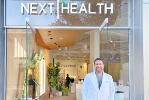 Dr. Darshan Shah poses in front of the Next Health entrance