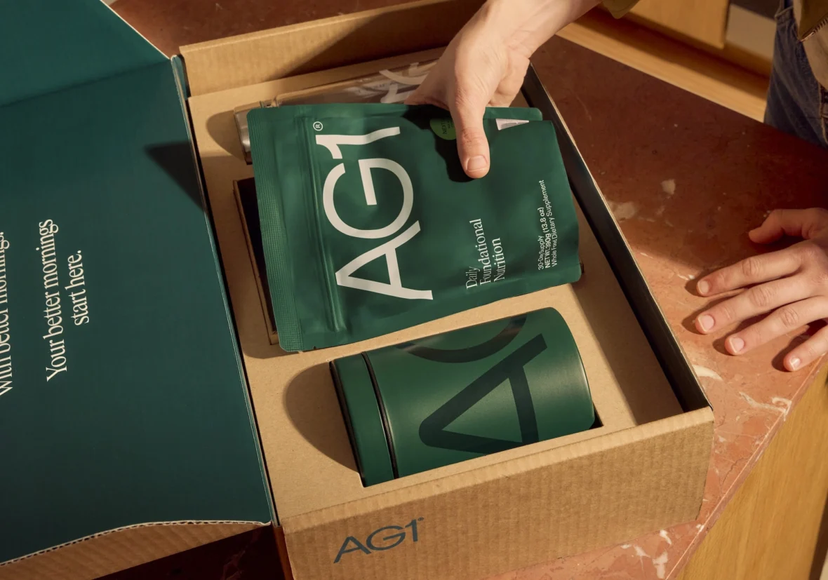woman unpacks AG1 supplement package
