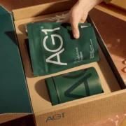 woman unpacks AG1 supplement package