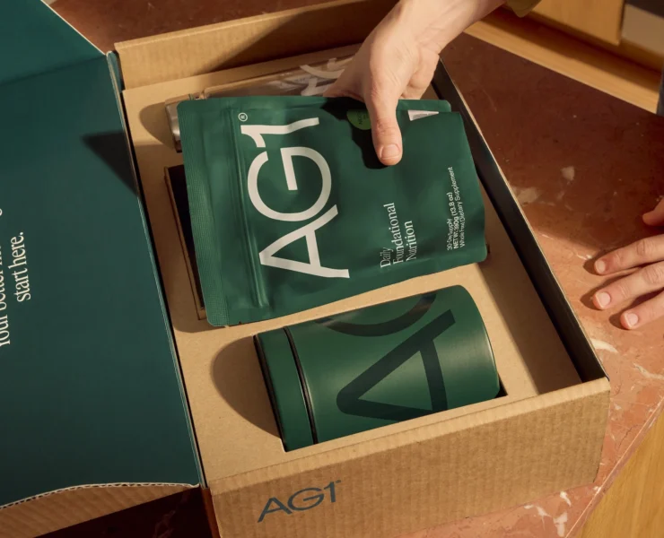 woman unpacks AG1 supplement package