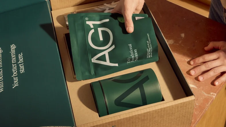 woman unpacks AG1 supplement package