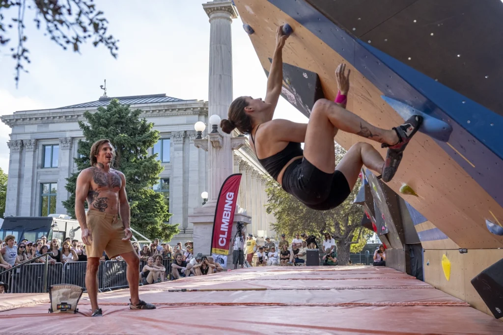 woman rock climbs at the Outside Festival 2024