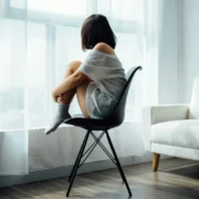 a woman looking out the window giving off morose vibes.