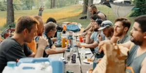 A group of men at a picnic table outside.